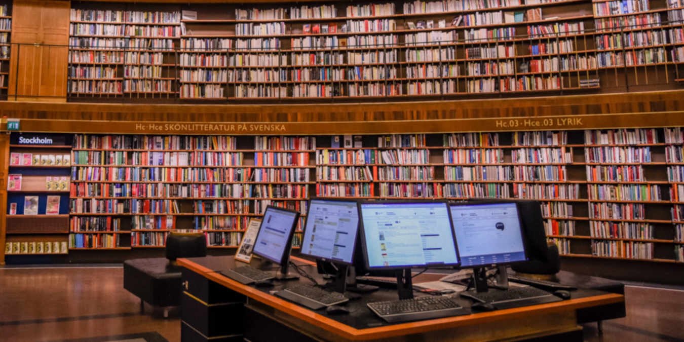 A photograph of a library with computer desktops.